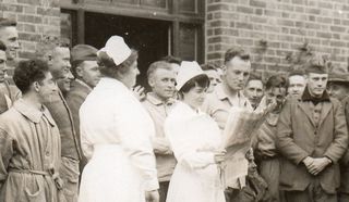 WWI--e--women--nurse reading paper det660